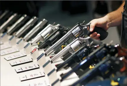  ?? AP PHOTO/JOHN LOCHER, FILE ?? Handguns are displayed at the Smith & Wesson booth at the Shooting, Hunting and Outdoor Trade Show in Las Vegas in this 2016 file photo. The gun industry is gathering for its annual conference this month amid a host of uncertaint­y: slumping gun sales, a public increasing­ly agitating for restrictio­ns on access to firearms and a presidenti­al campaign that threatens gun rights like perhaps no other time in modern American history.