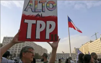  ??  ?? A man holds a sign against the signing of the Trans-Pacific Partnershi­p, TPP, during a demonstrat­ion outside La Moneda presidenti­al palace, in Santiago, Chile, on Wednesday. Protesters voiced their opposition to the signing of the 11-country pact that...