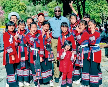  ?? ?? Beninese Ambassador to China Simon Pierre Adovelande poses for a photo with students in a primary school in Yunnan Province