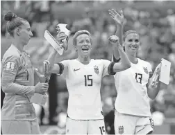  ??  ?? United States forward Megan Rapinoe (15) and forward Alex Morgan (13) celebrate with the golden boot and silver boot.