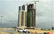  ?? —AFP ?? LAGOS: A car drives in front of modern skyscraper­s under constructi­on at Eko Atlantic City, Lagos. With frozen cranes, deserted constructi­on sites and empty buildings, Lagos is suffering a hangover from a constructi­on binge as Nigeria wrestles to...