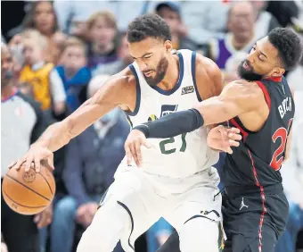  ?? GEORGE FREY THE ASSOCIATED PRESS ?? Khem Birch, who gave the Raptors a bit of a boost with a season-high 14 points, tries for the steal while defending Rudy Gobert of the Jazz in Thursday night’s game in Salt Lake City.