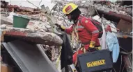  ?? RONALDO SCHEMIDT/AFP/GETTY IMAGES ?? Rescuers search Saturday for survivors in a flattened building in Mexico City. In the capital, the quake toppled 39 buildings, mostly in a central area.