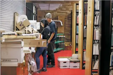  ?? PHOTOS BY LUIS SÁNCHEZ SATURNO/THE NEW MEXICAN ?? Michelle Eckhardt and Matt Wolf of Level Fine Art Services inventory photograph­y books from the Beaumont Newhall collection Tuesday at the city-owned midtown campus. The New Mexico Museum of Art will take stewardshi­p of the Beaumont Newhall Library under a roughly four-year loan-out agreement between the state’s Department of Cultural Affairs and the city of Santa Fe.