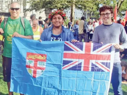  ??  ?? AnnMary Raduva, 15, with two others showcase the Fijian flag during the Global Climate Strike in New York City.