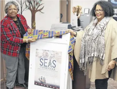  ?? DARRELL COLE ?? Crystal States, left, from the Office of African Nova Scotian Affairs, and former Cumberland African Nova Scotian Associatio­n executive director Elizabeth Cooke-Sumbu unveil a poster depicting the theme of this year’s African Heritage Month, Seas of Struggle – African Peoples from Shore to Shore.