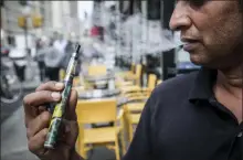  ?? BEBETO MATTHEWS — THE ASSOCIATED PRESS ?? Inam Rehman, manager of Jubilee Vape & Smoke Inc., vapes Monday while discussing New York Gov. Andrew Cuomo’s push to enact a statewide ban on the sale of flavored e-cigarettes amid growing health concerns in New York.