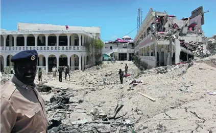  ?? Farah Warsameh / AP Photo ?? Somali soldiers inspect a building destroyed by a blast close to the presidenti­al palace in the capital Mogadishu yesterday, after a suicide bomber detonated an explosives-laden vehicle killing at least five people.