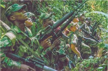  ?? FEDERICO RIOS/THE NEW YORK TIMES 2016 ?? A court in Colombia is exposing atrocities in the South American country’s long civil war. Above, a group of FARC rebels in the jungle months before the Colombian government struck a peace deal with the group.