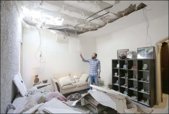  ??  ?? مواطن سعودي يتفقد الدمار في منزله عقب هجمات الحوثيين بصاروخ باليستي على العاصمة السعودية الرياض