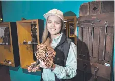  ??  ?? Lashai Carnie holds a set of metal roses, a bestseller made by the couple.