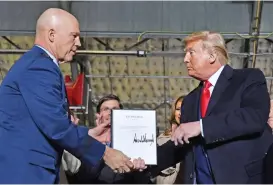  ?? (AFP) ?? US President Donald Trump (right) hands US General John W Raymond a document after signing the ‘National Defense Authorizat­ion Act for FY2020’ at Joint Base Andrews, Maryland on Friday