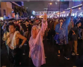  ?? (AP/Gemunu Amarasingh­e) ?? Pro-democracy demonstrat­ors regroup Friday after police cleared their protest venue in Bangkok.