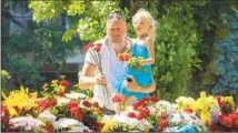  ?? Efrem Lukatsky Associated Press ?? A MAN and child visit a memorial for victims of the Russian missile attack on a shopping mall in Kremenchuk, Ukraine.