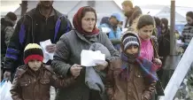  ?? BORIS GRDANOSKI/ THE ASSOCIATED PRESS ?? Refugees enter Macedonia after showing identifica­tion documents at a checkpoint on Sunday.