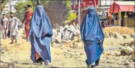  ?? AFP ?? NEW NORMAL: Women walk down a neighbourh­ood in Kabul on Wednesday.