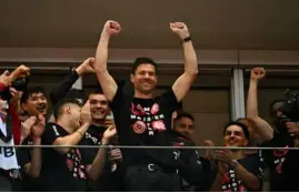  ?? AFP/VNA Photo ?? WINNING FEELING: Bayer Leverkusen's Spanish head coach Xabi Alonso celebrates with his players after they are crowned 2023-24 Bundesliga champions.