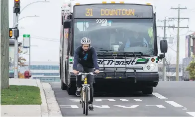  ?? DARREN STONE, TIMES COLONIST ?? A cyclist travels ahead of a transit bus in the southbound bus lane on Douglas Street, near Burnside Road East.