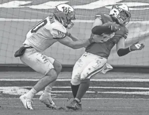  ?? JIM DEDMON / USA TODAY SPORTS ?? Wake Forest quarterbac­k Sam Hartman tries to stop Badgers safety Collin Wilder after his intercepti­on in the second half Wednesday.