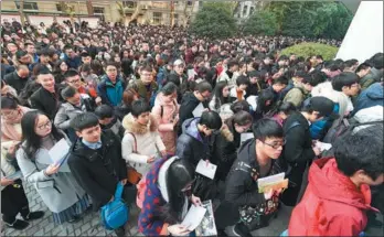  ?? SUN CAN / XINHUA ?? Applicants line up to enter classrooms at Nanjing Forestry University, a National Public Servant Exam testing center, in Nanjing, Jiangsu province, on Sunday. Nationwide, more than 1.1 million people took the test. More than 28,000 positions are available for examinees, but only one of every 39 candidates is expected to land a government job this year.