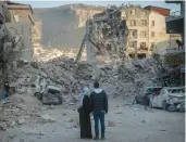  ?? CHRIS MCGRATH/GETTY ?? A couple look over buildings destroyed by the Feb. 6 quake Sunday in Turkey’s Hatay province.