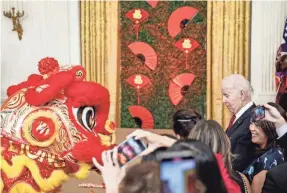  ?? ANNA MONEYMAKER/GETTY IMAGES ?? President Joe Biden watches the Choy Wun Lion Dance Troupe last week at a Lunar New Year reception at the White House.