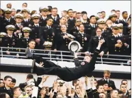  ?? Matt Slocum / Associated Press ?? A Navy midshipman is tossed in the air as fans celebrate a touchdown against Army in 2015.