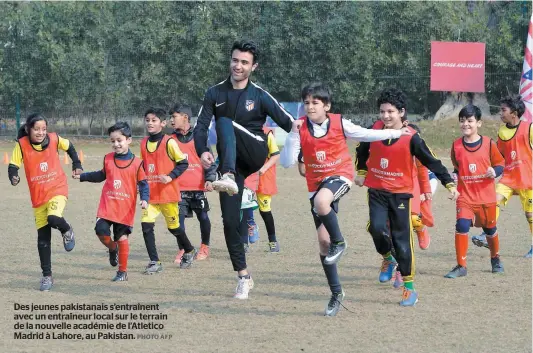  ?? PHOTO AFP ?? Des jeunes pakistanai­s s’entraînent avec un entraîneur local sur le terrain de la nouvelle académie de l’atletico Madrid à Lahore, au Pakistan.