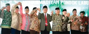  ?? HENDRA EKA/JAWA POS ?? TURUN GUNUNG: Din Syamsuddin (lima dari kanan) dan Jimly Asshiddiqi­e (lima dari kiri) bersama pengurus Ranting Muhammadiy­ah Pondok Labu setelah acara pelantikan kemarin.