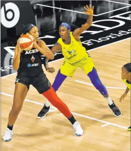  ?? Steve Nesius The Associated Press ?? Aces forward A’ja Wilson looks to pass while under pressure from Dallas Wings forward Astou Ndour during the first half of Las Vegas’ 79-70 WNBA triumph Sunday.