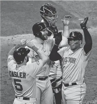  ?? Yi-Chin Lee / Staff photograph­er ?? Red Sox third baseman Rafael Devers, right, is welcomed after striking the biggest blow of Game 5, a three-run homer in the sixth inning.