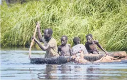  ?? MAURA AJAK/AP ?? Some 1 million people in South Sudan have been displaced or isolated for months by the worst flooding in memory. Above, a father and his sons move cows Nov. 25.