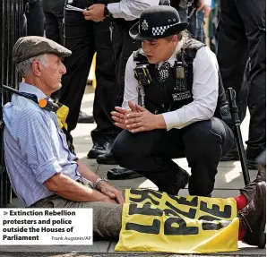  ?? Frank Augstein/AP ?? > Extinction Rebellion protesters and police outside the Houses of Parliament