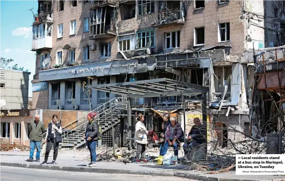  ?? Alexei Alexandrov/Associated Press ?? Local residents stand at a bus stop in Mariupol, Ukraine, on Tuesday