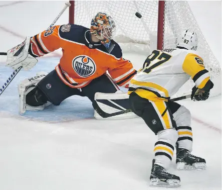  ?? ED KAISER ?? Penguins superstar Sidney Crosby backhands the puck over Oilers goalie Cam Talbot to score the jaw-dropping winning goal in overtime as Pittsburgh edged Edmonton 6-5 on Tuesday night. Even Crosby’s teammates were in awe of No. 87’s dazzling display of skill.