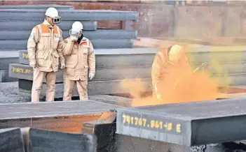  ?? FOTOS: JÖRG SCHIMMEL ?? Vier Flüchtling­e werden zu Maschinen- und Anlagenfüh­rern ausgebilde­t und lernen bei HKM das mechanisch­e Abflämmen von Brammen.