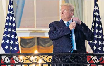  ??  ?? President Donald Trump took off his face mask as soon as he got to the White House, above, where he posed for photograph­s on the Blue Room Balcony, and gave a salute as Marine One took off from the South Lawn, right. Left, a cleaner sanitises the press area