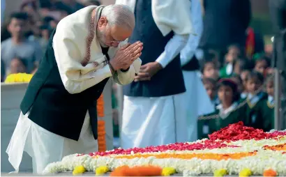  ?? AFP ?? Prime Minister Narendra Modi pays homage at Rajghat, the memorial of Father of the Nation Mahatma Gandhi, on Martyrs’ Day in New Delhi on Monday, the 69th anniversar­y of Gandhi’s assassinat­ion. Mahatma Gandhi was on the way to a prayer meeting in the...