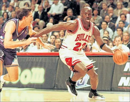  ?? GETTY IMAGES FILE ?? Chicago Bulls’ Michael Jordan sticks out his tongue as he goes past Jeff Hornacek of the Utah Jazz during Game 2 of the NBA Finals on June 4, 1997.