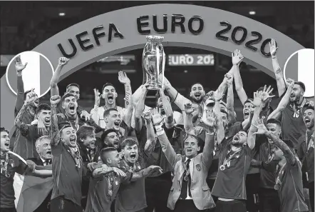  ?? AFP ?? The Italy squad celebrates as captain Giorgio Chiellini raises the European Championsh­ip trophy following the Azzurri’s penalty shootout victory over England in Sunday’s final at Wembley Stadium in London.