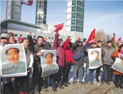  ?? —AFP ?? Residents hold posters of late communist leader Mao Zedong during a protest calling for a boycott of South Korean goods in Jilin, in China’s northeast Jilin province yesterday.