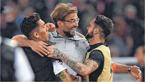  ?? FOTO: AFP ?? Vorerst am Ziel aller Träume: Liverpools Trainer Jürgen Klopp feiert mit Mittelfeld­spieler Roberto Firmino ( links) und Danny Ings.