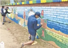  ??  ?? Los jóvenes del Colectivo Cultural pintan el mural.