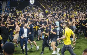  ?? (Oren Ben Hakoon/Flash90) ?? BEITAR JERUSALEM FANS storm the field after the State Cup final between Maccabi Netanya and Beitar Jerusalem at the Sammy Ofer Stadium in Haifa on Tuesday night.