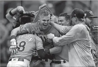  ?? CHRIS O'MEARA/AP PHOTO ?? Jake Bauers of the Rays, center, celebrates with teammates after his walkoff home run in the 12th inning of Sunday’s game against the Yankees at St. Petersburg, Fla.