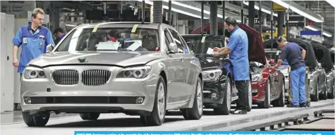  ??  ?? DINGOLFING: Employees working at the assembly line of the German carmaker BMW plant in Dingolfing, southern Germany. EU antitrust regulators raided German car manufactur­ers yesterday. —AFP