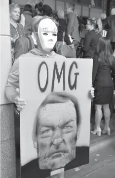  ?? AGENCE FRANCE PRESSE ?? A protester holds a sign as Cardinal George Pell arrives at the Victorian Magistrate­s Court for an expected month-long committal hearing relating to historical sexual offense charges in Melbourne.