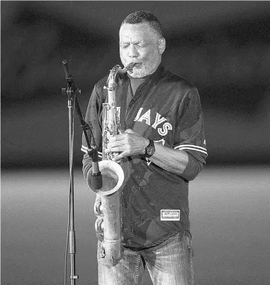  ?? Paul Chiason / THE CANADIAN PRESS ?? Russell Martin Sr., right, father of Blue Jays catcher Russell Martin, played the national anthems on his saxophone during the pre-game ceremony,
dampening many an eye, including his son’s. The crowd also paid loud tributes to some former Expos,...