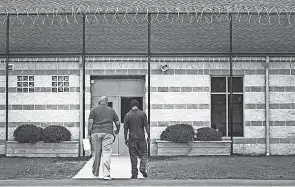  ?? ?? A staff member escorts a youthful offender at the Circlevill­e Juvenile Correction­al Facility south of Columbus in Pickaway County.