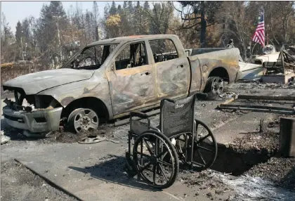  ?? AP PHOTO ?? A scorched truck and wheelchair sit outside the charred remains of a house in the Coffey Park area of Santa Rosa, Calif., Monday.